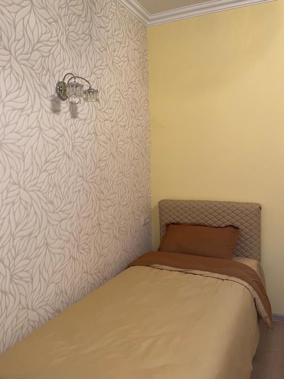 1 dormitorio con 1 cama con pared en Roman's guest house in Garni en Garni