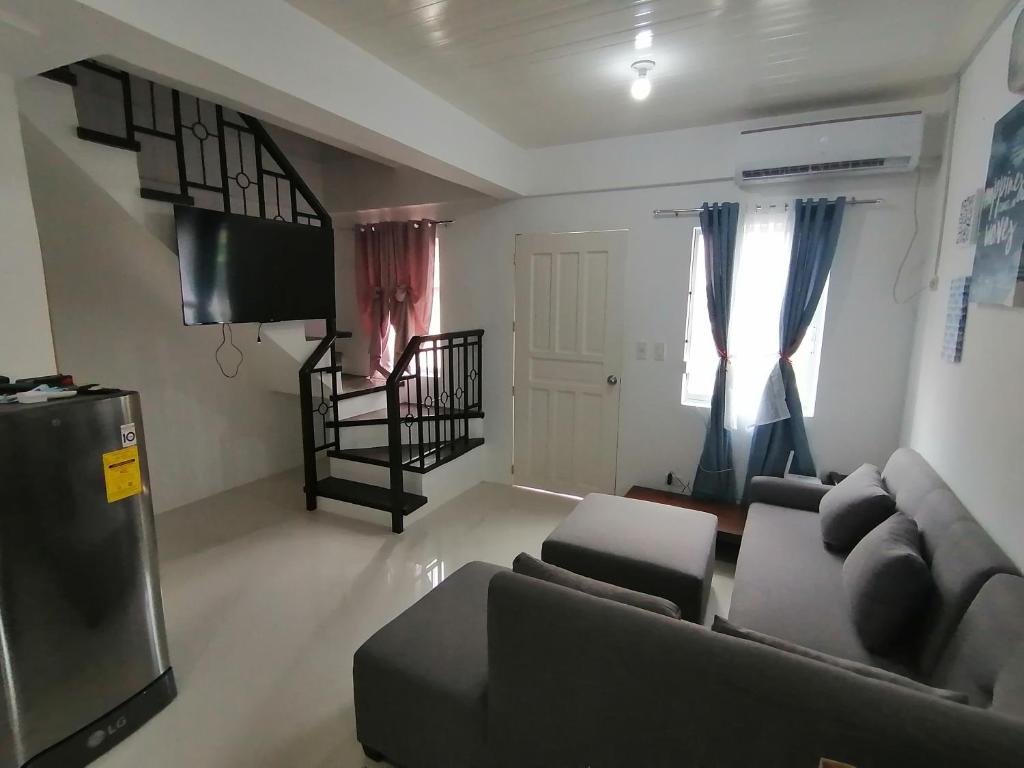 a living room with a couch and a flat screen tv at CAMILA Homes Transient house /vacation house in Butuan