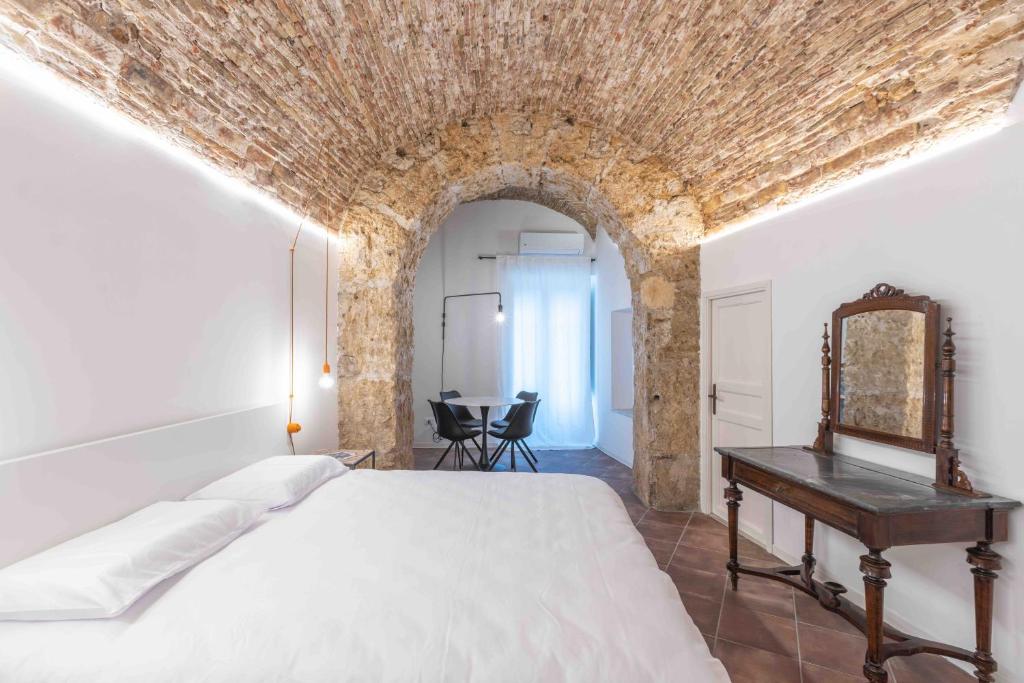 sypialnia z łóżkiem i stołem z lustrem w obiekcie Calderai 82 suites 1 e 2 w mieście Palermo