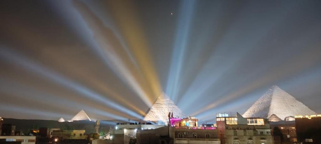 - une vue sur les pyramides d'une ville la nuit dans l'établissement Falcon pyramids inn, au Caire