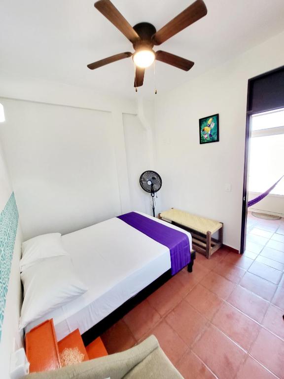 a bedroom with a bed and a ceiling fan at Casa Puerto Bonito & Private Coworking in Puerto Escondido