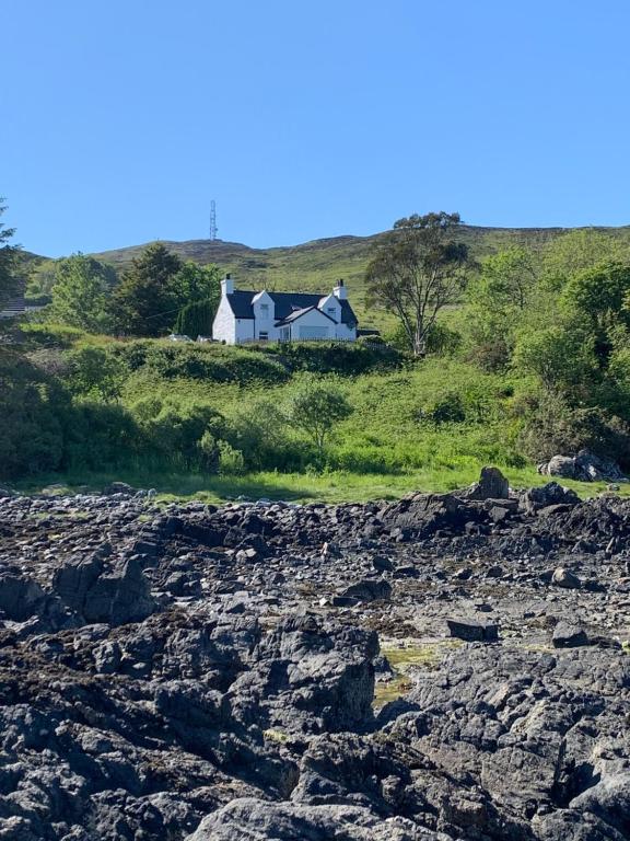 a house on top of a hill with a rocky field at Tighnamara-Skye in Saasaig