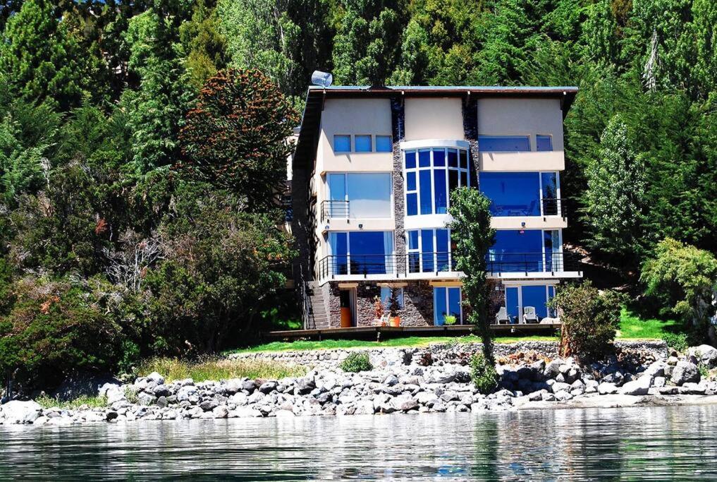 una casa en la orilla de un cuerpo de agua en La Casa del Lago Nahuel en San Carlos de Bariloche