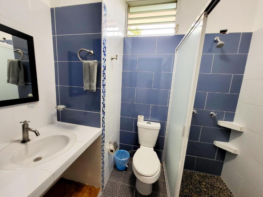 a blue tiled bathroom with a toilet and a sink at Casa Puerto Bonito & Private Coworking in Puerto Escondido