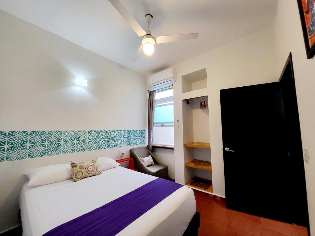 a small bedroom with a bed and a window at Casa Puerto Bonito & Private Coworking in Puerto Escondido