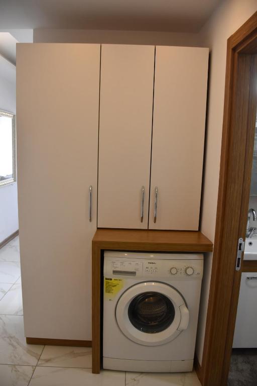 a laundry room with a washing machine and cabinets at Serenity Apart in Antalya