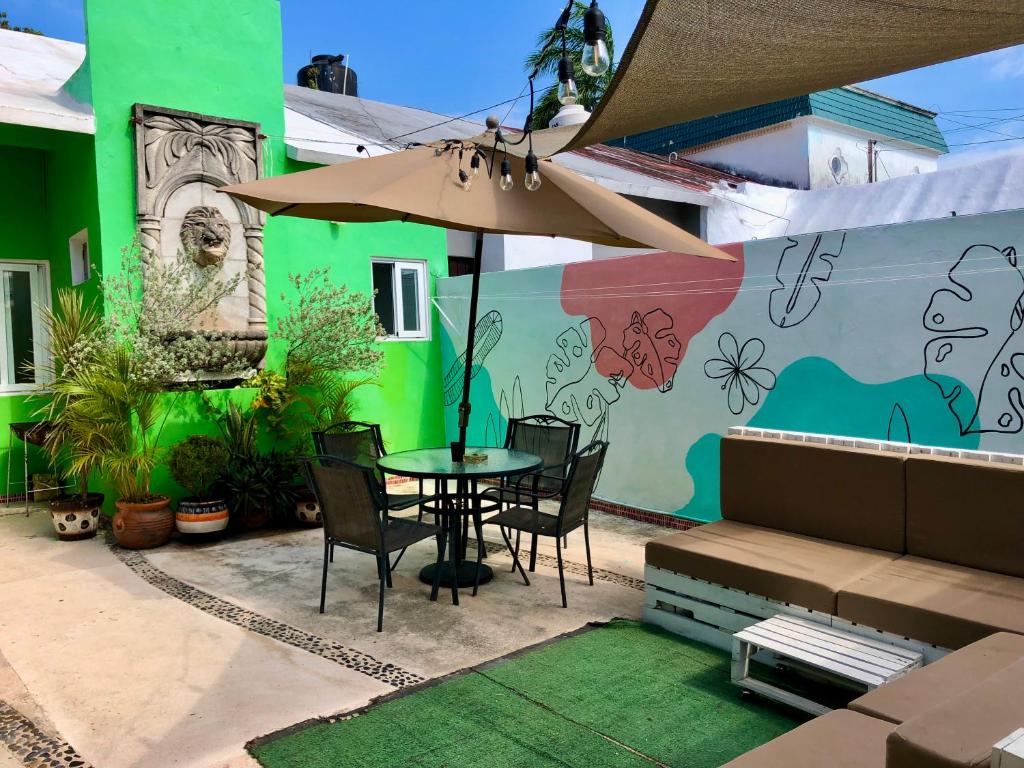 een patio met een tafel en stoelen en een muurschildering bij Villa Leo in Cancun