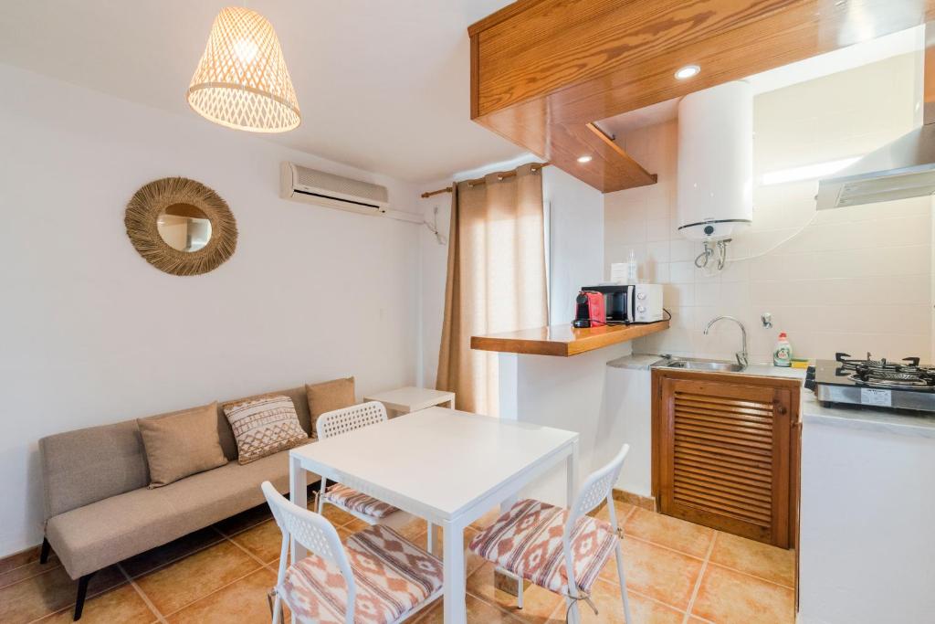 cocina y sala de estar con mesa y sofá. en Apartamentos Mayans en Sant Ferran de Ses Roques