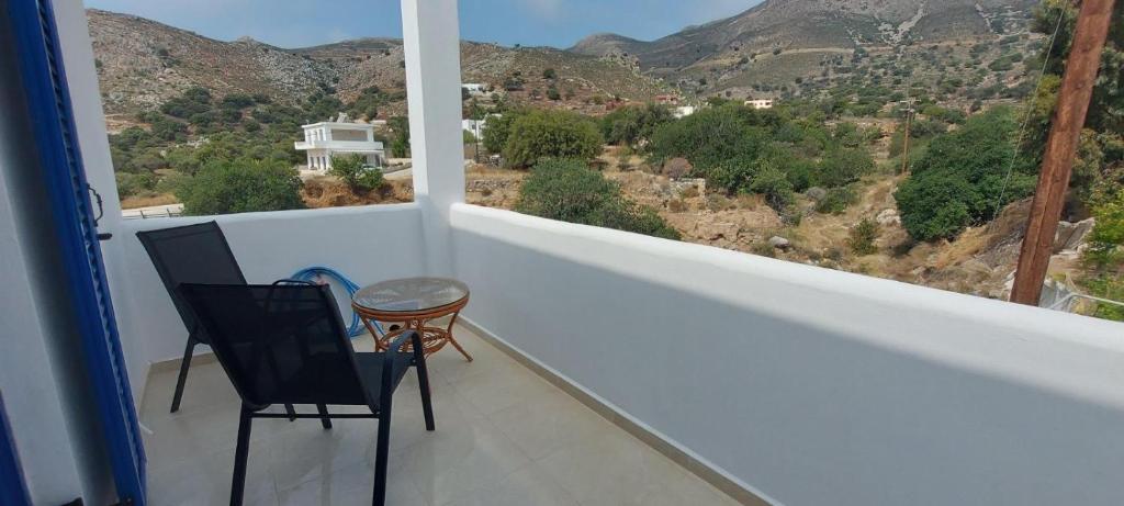 a balcony with two chairs and a table and a view at Dionysia apartments in Livadia