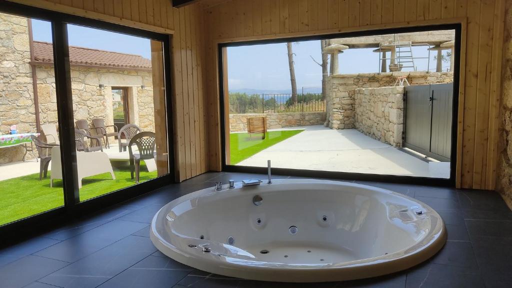 a large tub in a room with large windows at A Casa de Elisa in Laxe