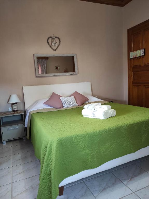 a bedroom with a green bed with towels on it at Angelic House in Spetses