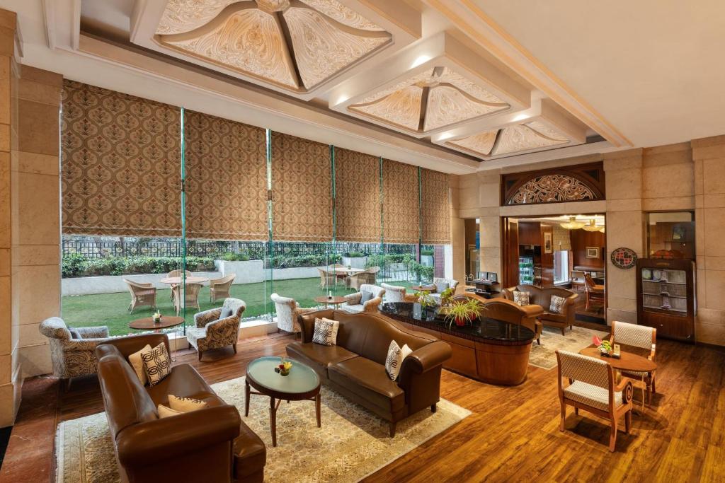 uma grande sala de estar com mobiliário e uma grande janela em Sheraton New Delhi Hotel em Nova Deli