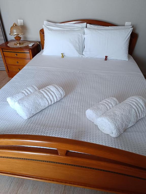 a bed with two pillows and two towels on it at Panos House - Warm and cozy retreat in Tríkala