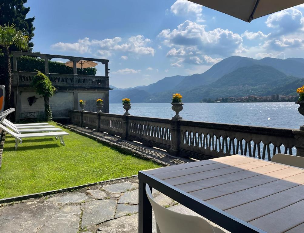 a bench sitting on the grass next to a body of water at Exclusive-LakeView Bella Vista Orta G&G in Omegna