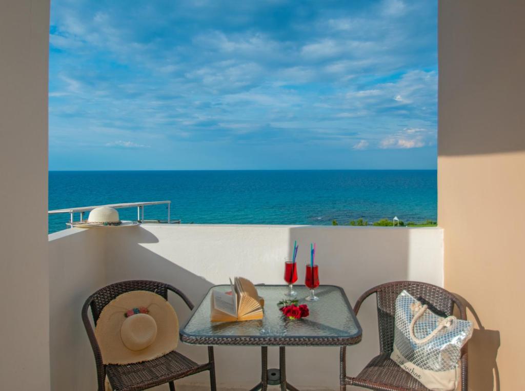 una mesa y sillas en un balcón con vistas al océano en Kozanos Studios 1, en Amoudi