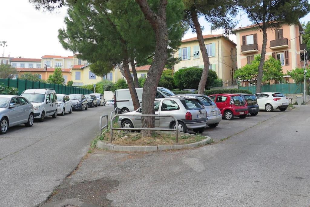 una fila di auto parcheggiate sul lato di una strada di Petit Paradis a Nizza