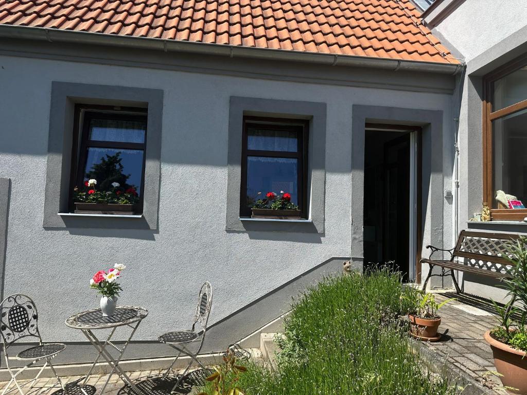 a house with two windows and a table and chairs at Apartmán U jezírka in Velké Přílepy