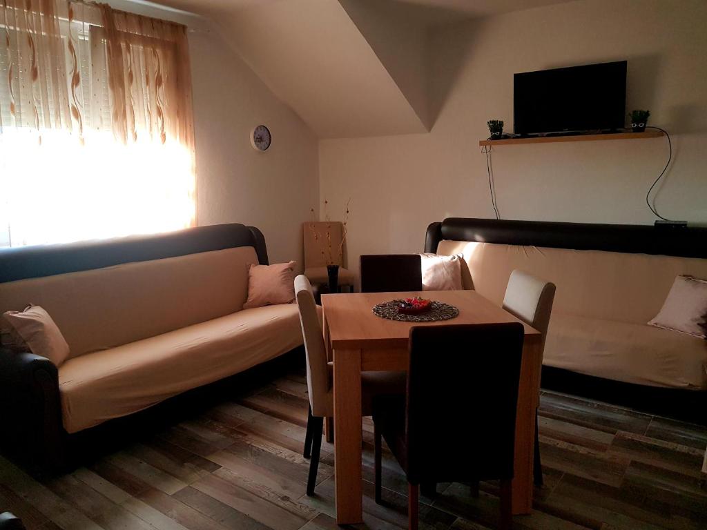 uma sala de estar com um sofá e uma mesa em Apollon home apartments em Bar