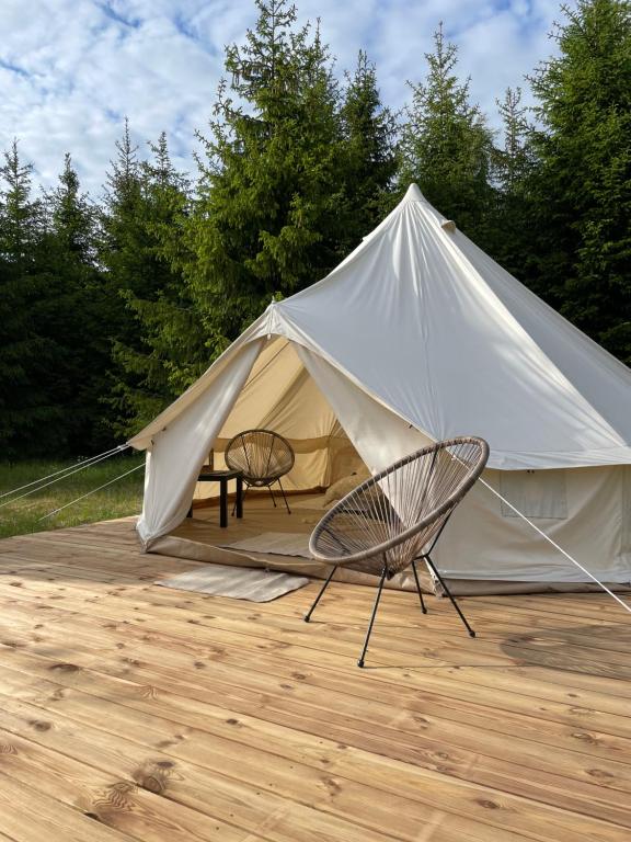 une tente avec deux chaises, une table et une chaise dans l'établissement Restu Forrest Glamp, à Otepää