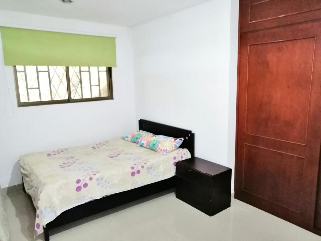 a bedroom with a bed and a wooden door at Casa en Condominio Santa Helena in Yaguará