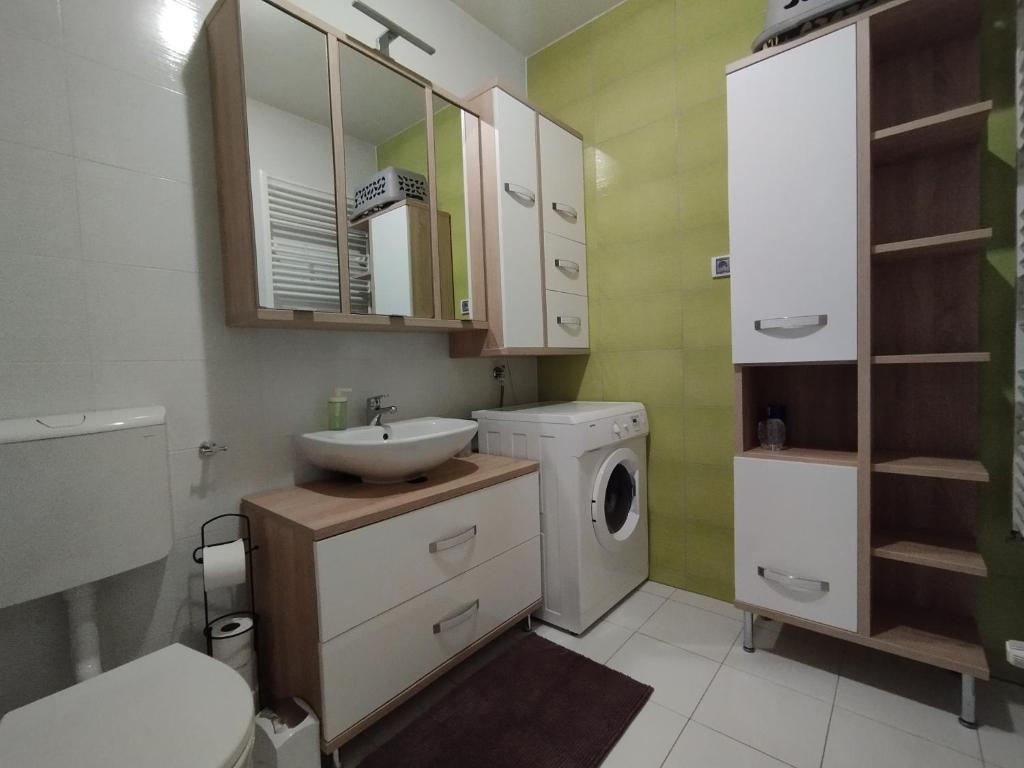 y baño con lavabo y lavadora. en Apartment Bencic, en Umag