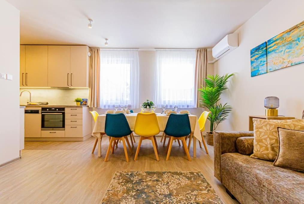 eine Küche und ein Wohnzimmer mit einem Tisch und Stühlen in der Unterkunft Roomy apartment 80sqm at city center FREE PARKING space, AC & balcony in Budapest