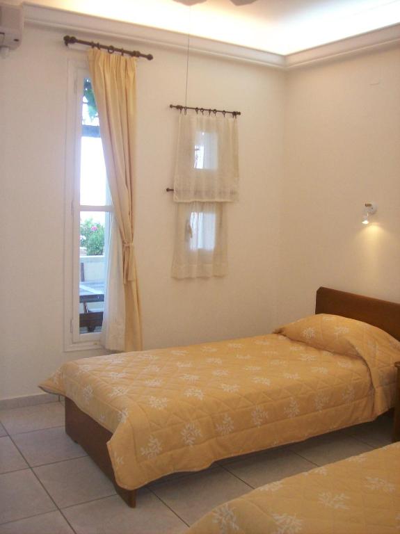 a bed in a room with a window and a bedvisor at Vassiliki Studios in Andros