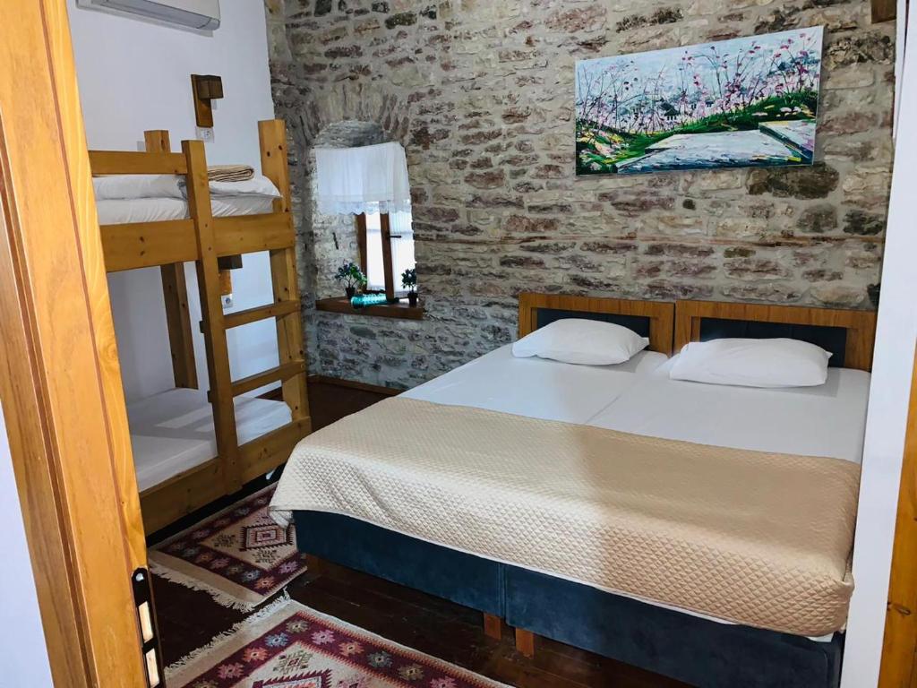 a bedroom with a bed and a bunk bed at Guest House and Hostel VAL-MAR in Gjirokastër