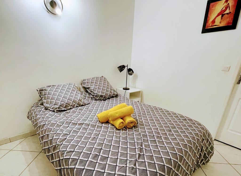 un oso de peluche amarillo tirado en una cama en Agréable appartement F2 à Le Perreux-Sur-Marne, en Le Perreux-Sur-Marne