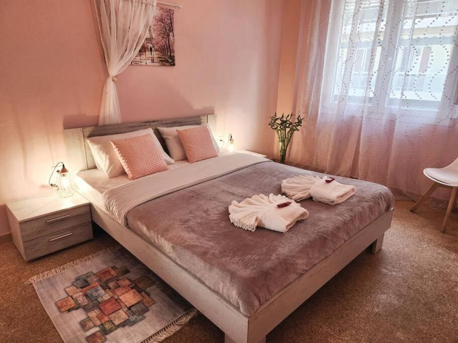 a bedroom with a large bed with two towels on it at Kallithea’s Heart greendom in Athens