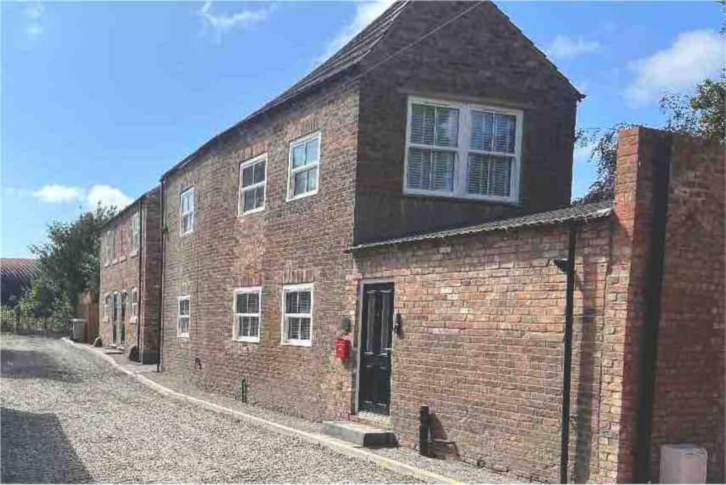 a brick building with a door on a street at Cosy newly renovated 3 bedroom house - Town centre Horncastle in Lincolnshire
