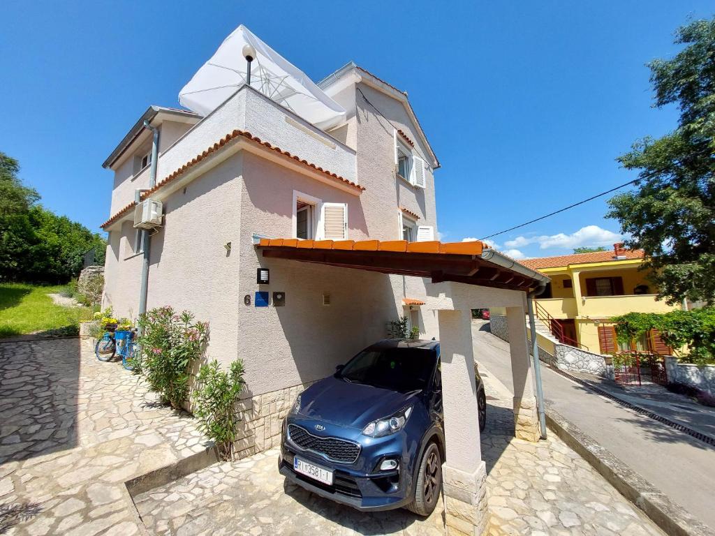 un coche aparcado frente a una casa pequeña en Apartment Marino, en Čižići