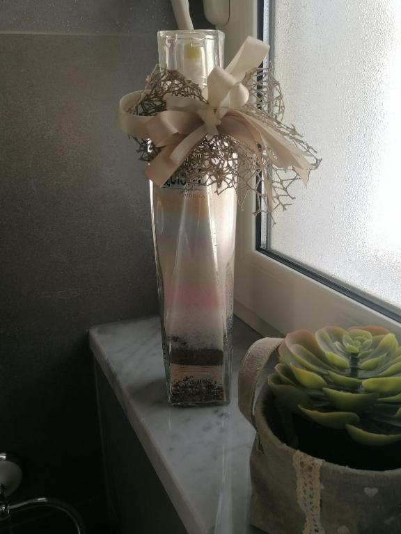 a vase filled with water and a bow on a table at Casa Gimaga in Pozzuoli