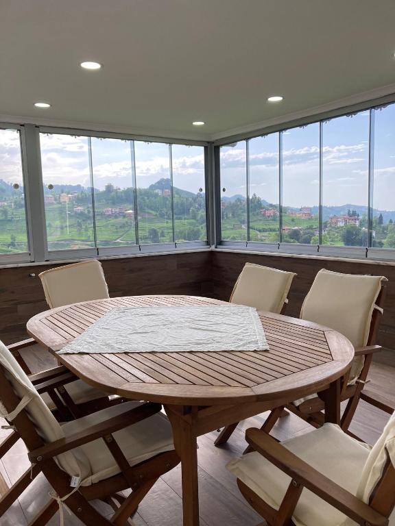 a table and chairs in a room with windows at Doğa içinde ferah huzurlu müstakil ev in Of