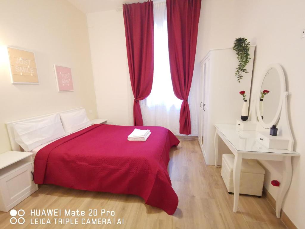 - une chambre avec un lit rouge et un bureau blanc dans l'établissement Casa di Serena, à Mestre