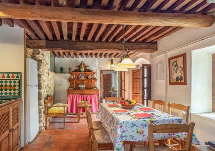 cocina y comedor con mesa y sillas en Molino del Caracol, en Benaoján