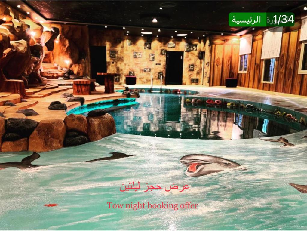 een groot zwembad met dolfijnen in het water bij شاليهات ليالي زين الشرف 1 in Taif