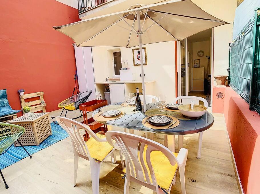 - une table avec des chaises et un parasol dans la chambre dans l'établissement Appartement Terrasse Proche Port et Plages de Nice, à Nice