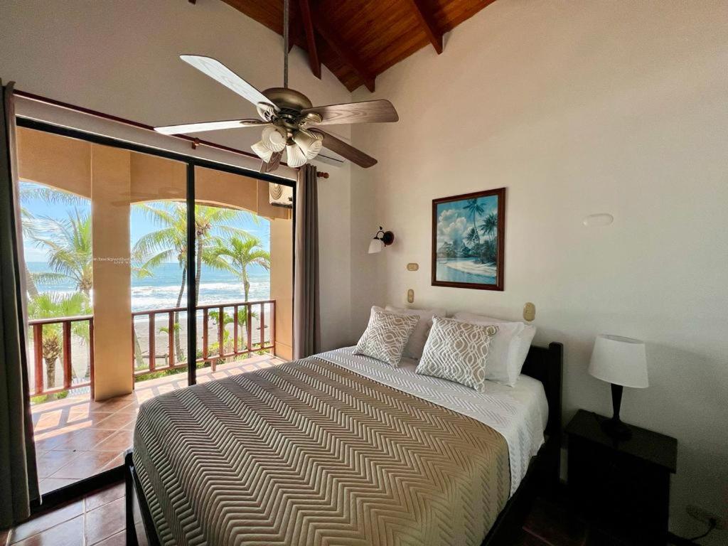 1 dormitorio con 1 cama y ventilador de techo en The Backyard Beachfront Hotel, en Jacó