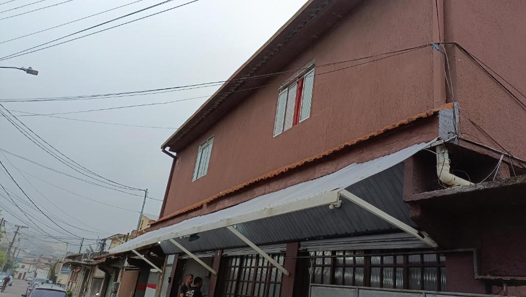 Pousada do Gil في تيريسوبوليس: مبنى بني كبير مع مظلة عليه
