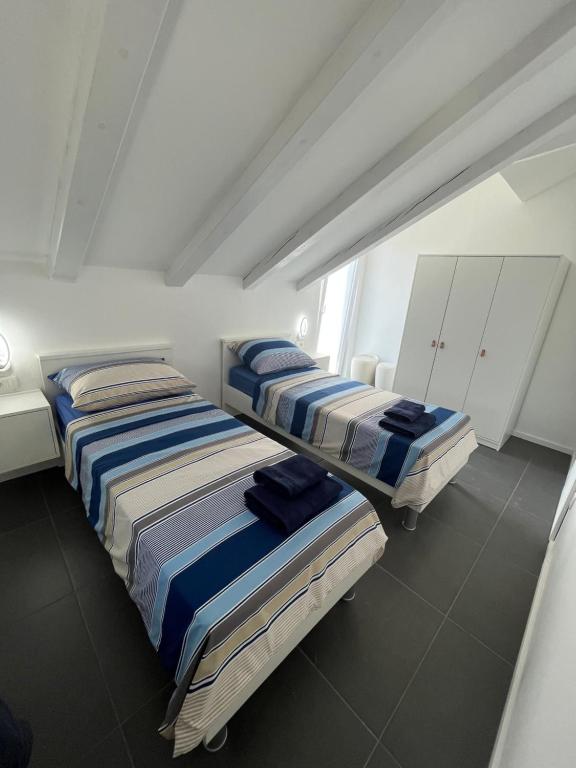 Apartmani Kamil في مارينا: سريرين في غرفة بجدران بيضاء