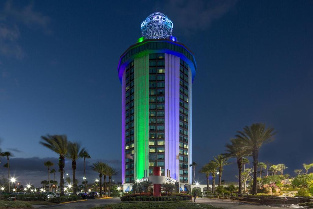 a tall building lit up in green and blue at Four Points by Sheraton Orlando International Drive in Orlando