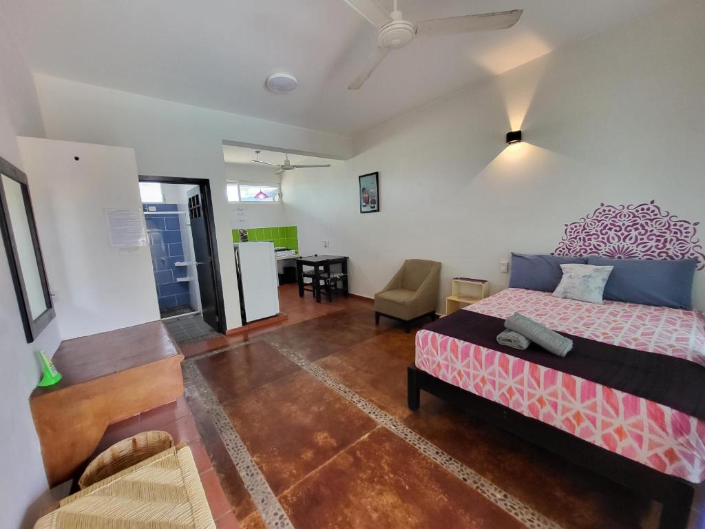 a bedroom with a bed and a living room at Casa Puerto Bonito & Private Coworking in Puerto Escondido