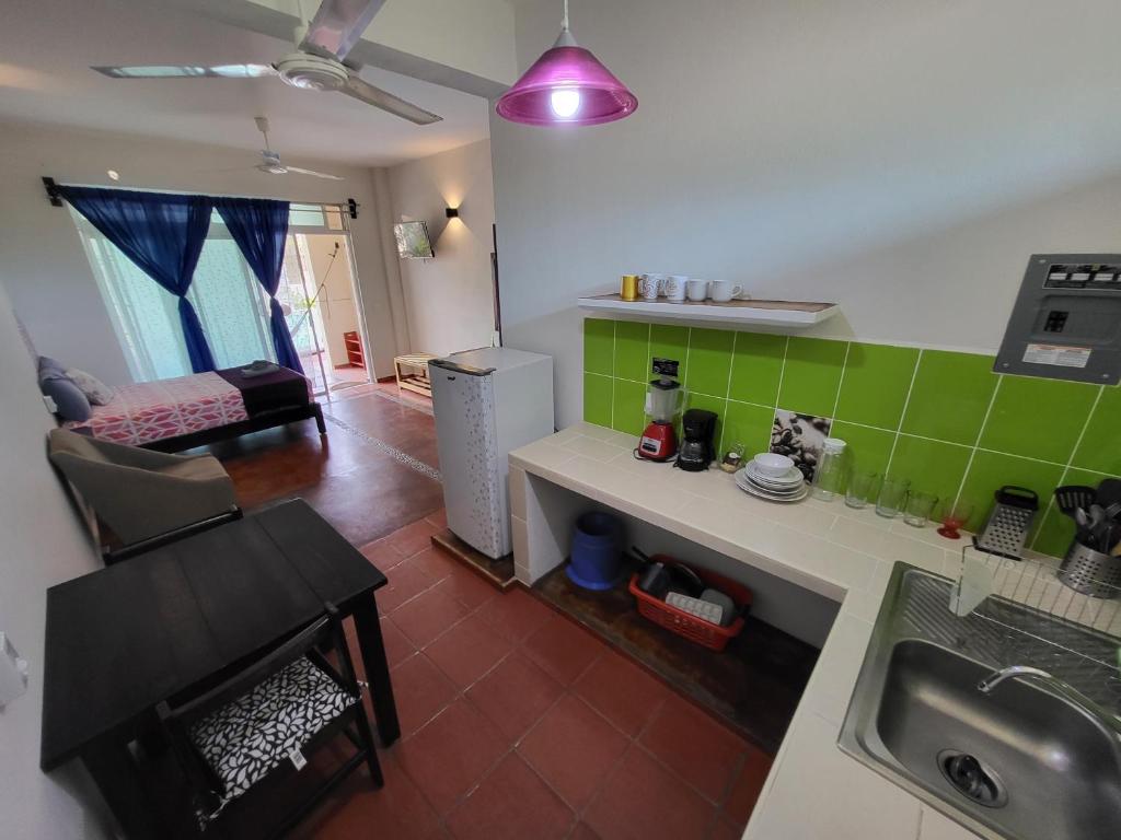 a kitchen with a sink and a living room at Casa Puerto Bonito & Private Coworking in Puerto Escondido