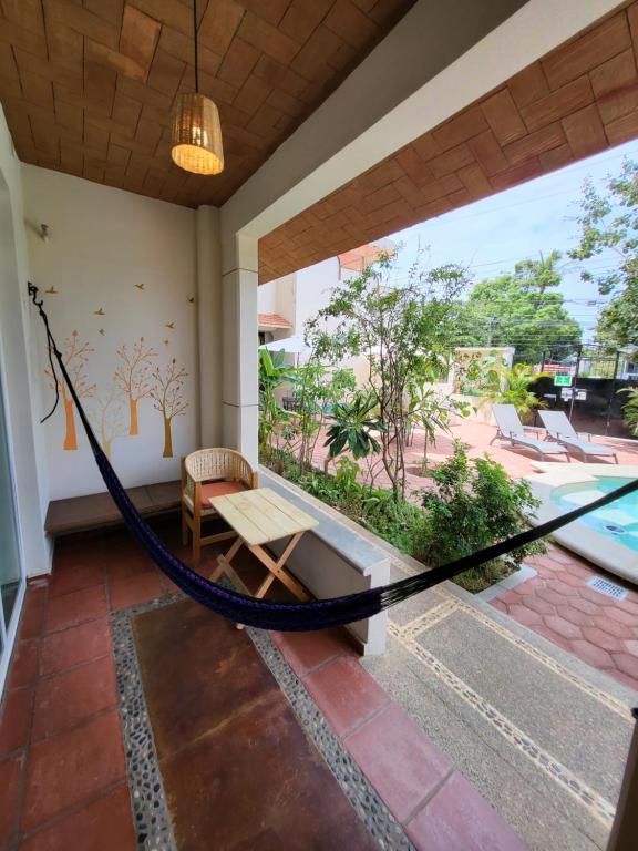a porch with a hammock and a pool at Casa Puerto Bonito & Private Coworking in Puerto Escondido