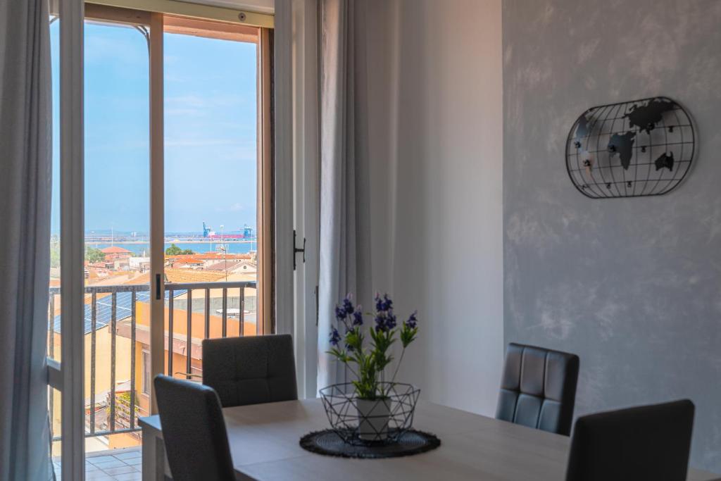 Un comedor con una mesa y una ventana. en Almi - Guest Apartment, en Porto Torres