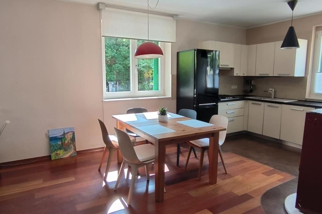 eine Küche mit einem Holztisch mit Stühlen und einem Kühlschrank in der Unterkunft Apartman Sonja in Lovran