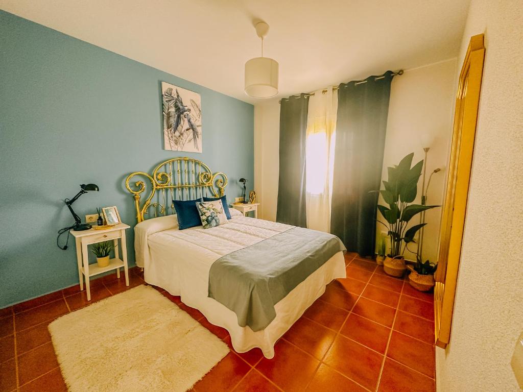 um quarto com uma cama e uma parede azul em DeCapi House em Sanlúcar de Barrameda