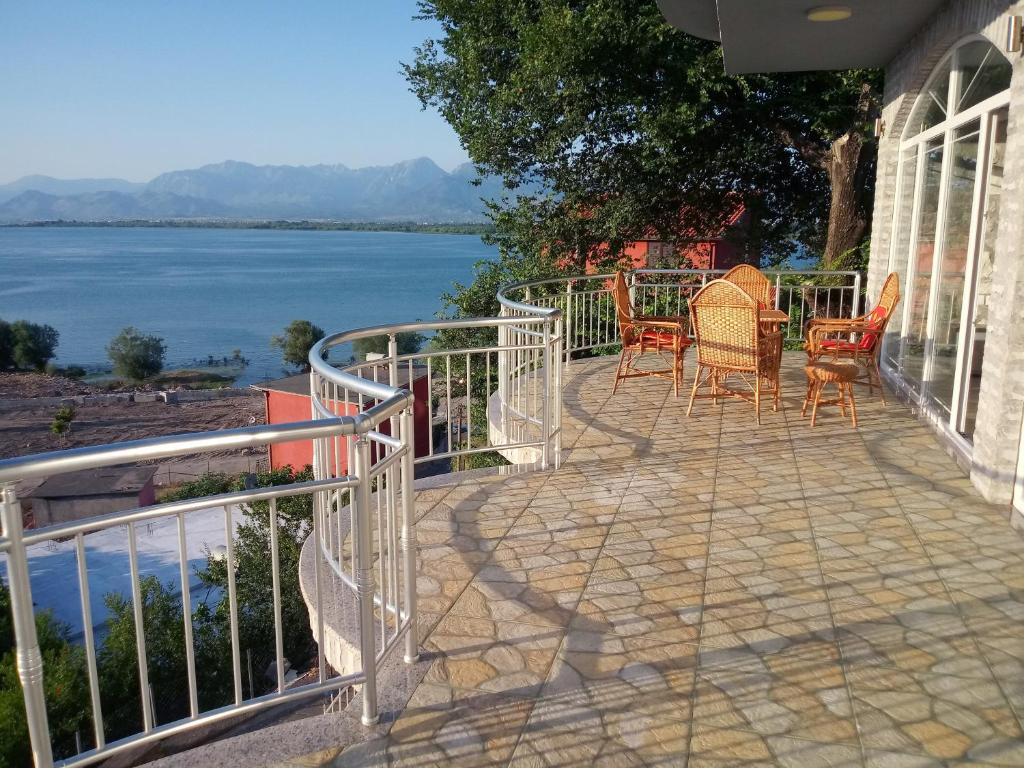 un patio con sillas y vistas al agua en Hyka The Stone House en Shkodër