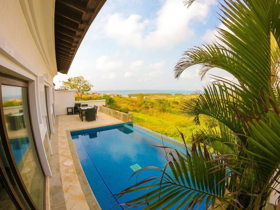 a swimming pool with a view of the ocean from a house at Relax Enjoy Upscale Villa Pristine Bay in Roatán